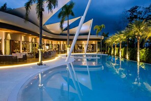 Una piscina al aire libre, sillones reclinables de piscina