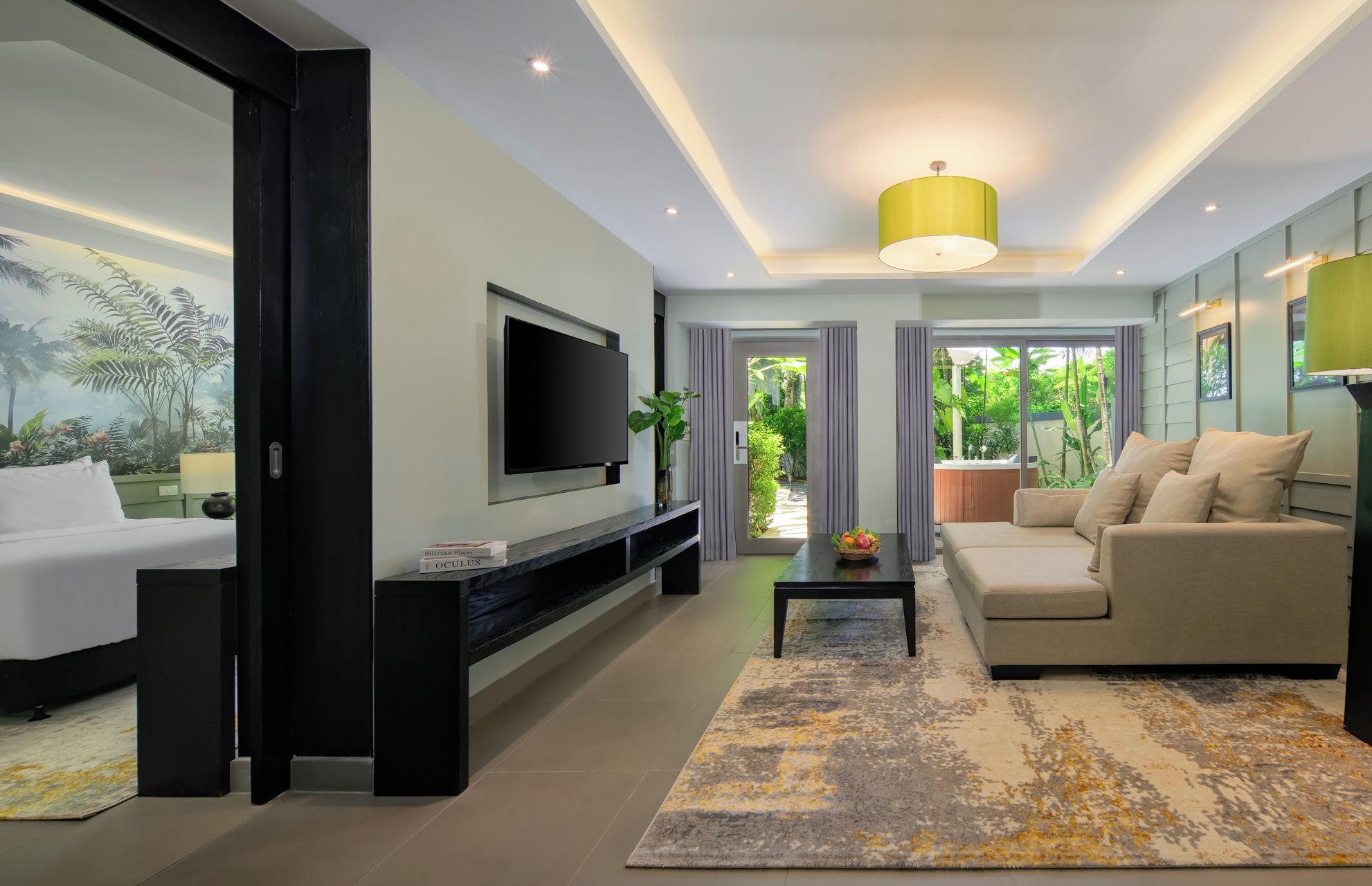A modern living room with a flat-screen TV, a sofa, a coffee table, and a large window with a view of greenery.