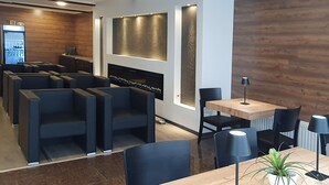 Un restaurante moderno con asientos oscuros, una mesa de madera y una planta en maceta.