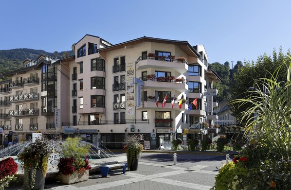 Un hotel de varios pisos con balcones, un cartel que indica que es un hotel y vistas del entorno.