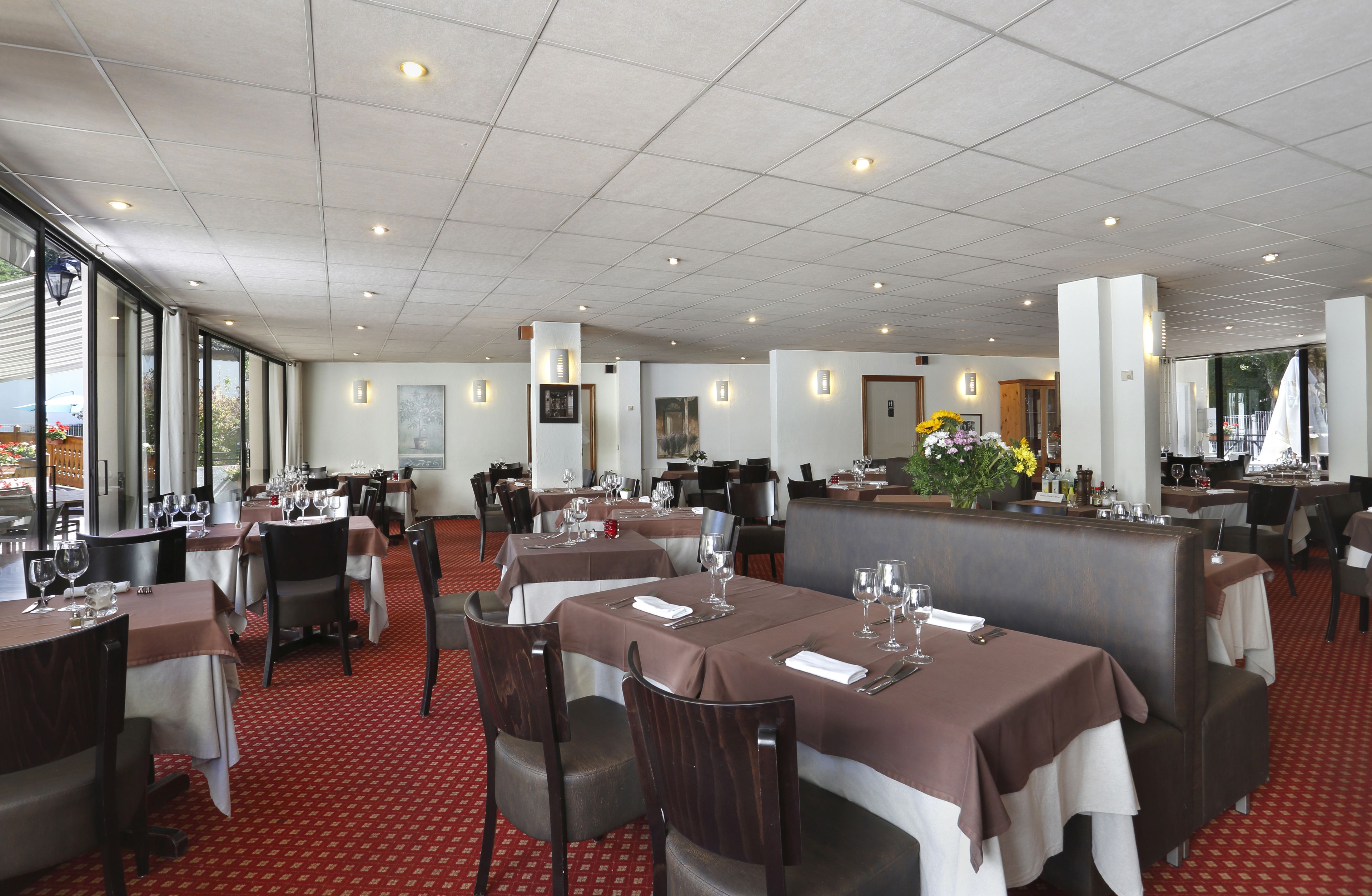 Un restaurante con varias mesas, sillas y cabinas.