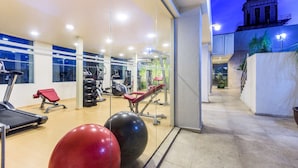 A gym with exercise equipment, a treadmill, and a red exercise ball. - NH Puebla Centro Histórico (Puebla)