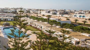 Un resort con piscina, palmeras y vistas a la ciudad.