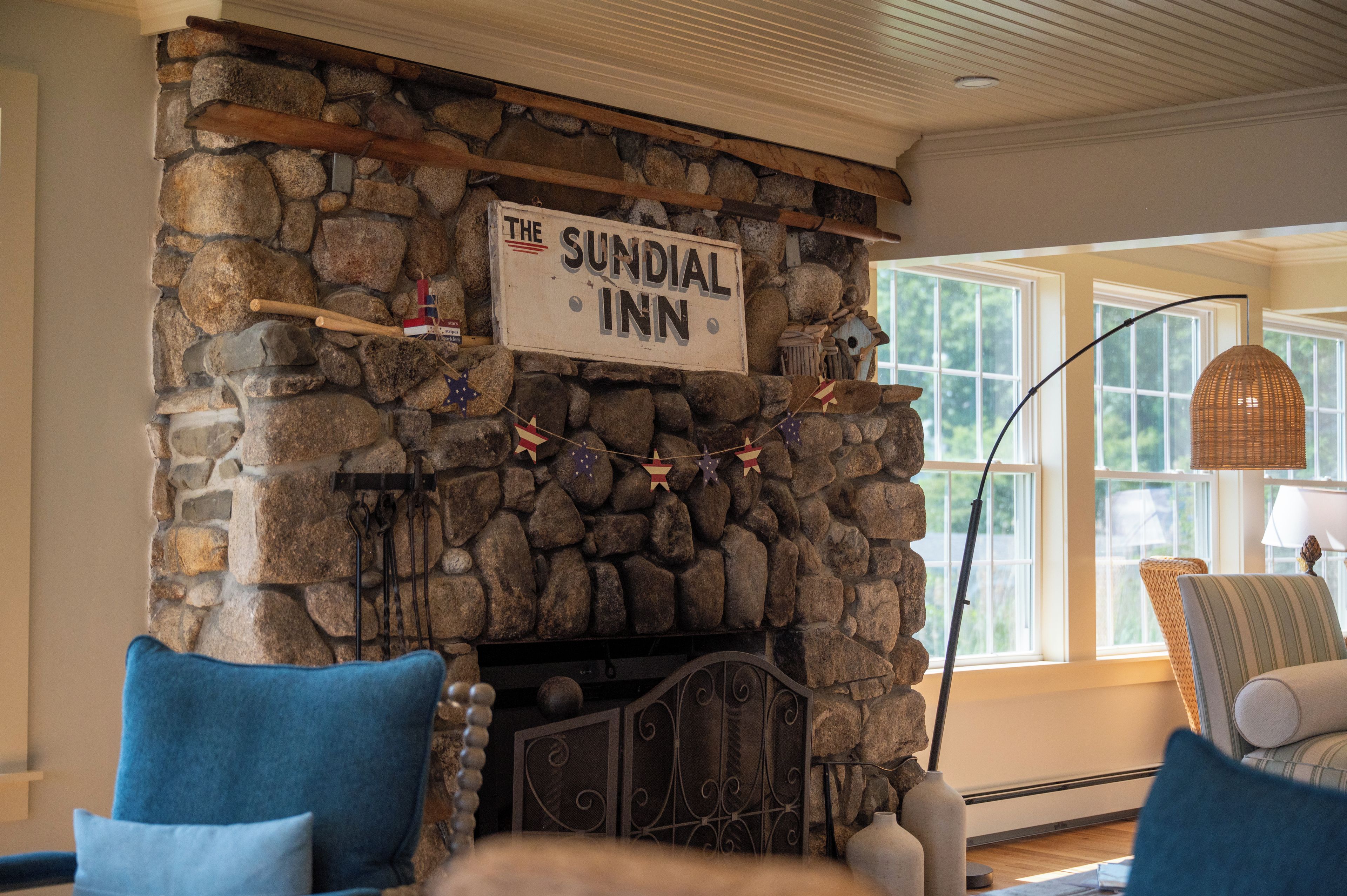 A stone fireplace with a sign reading 'The Sundial Inn' above it.