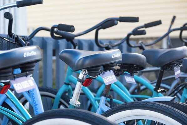 A row of electric bicycles branded 'Electra' with a tag reading 'BEACH HOUSE INN.' - The Beach House Inn (Kennebunk)