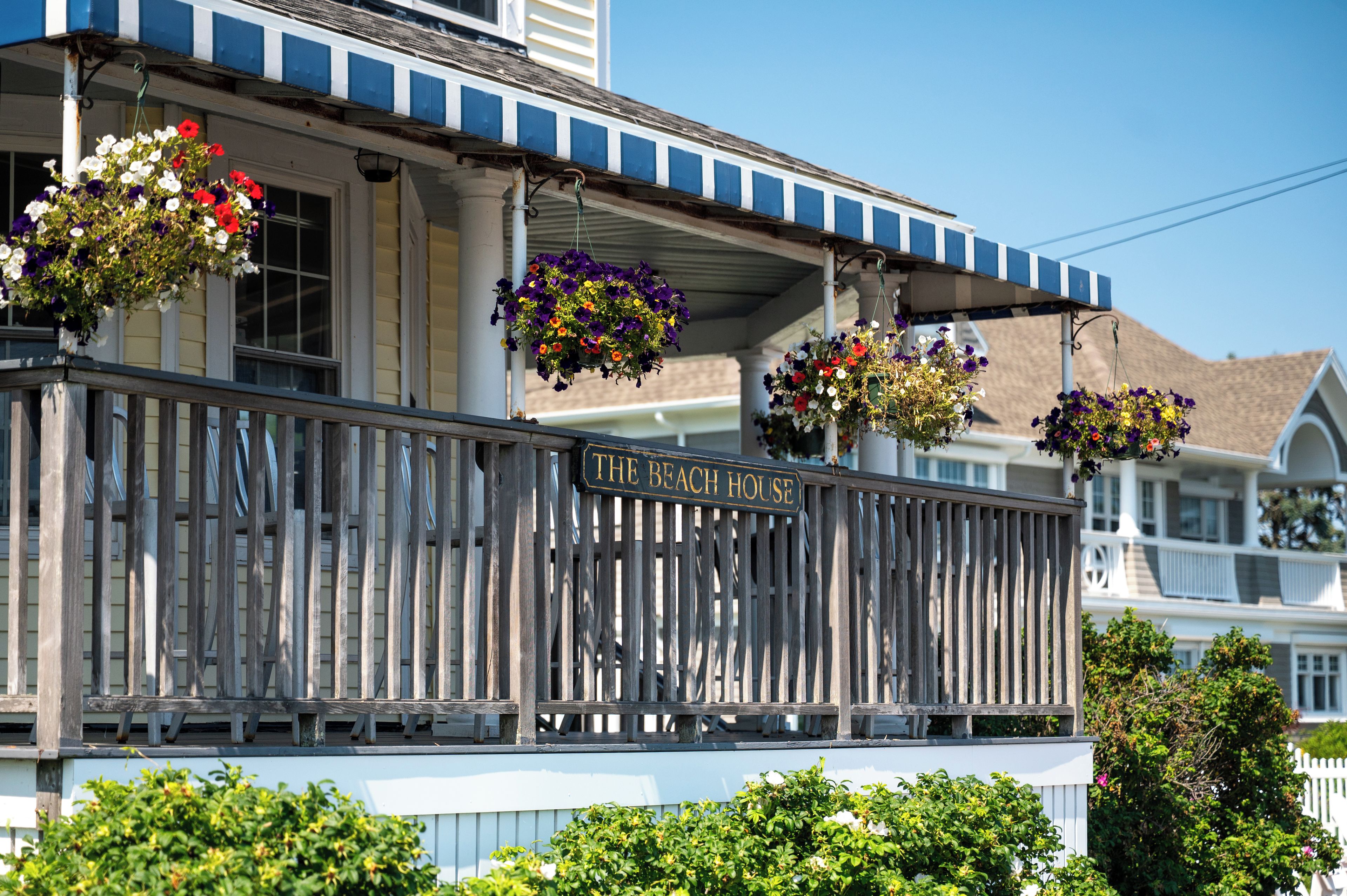 A building with a balcony adorned with hanging flower baskets.