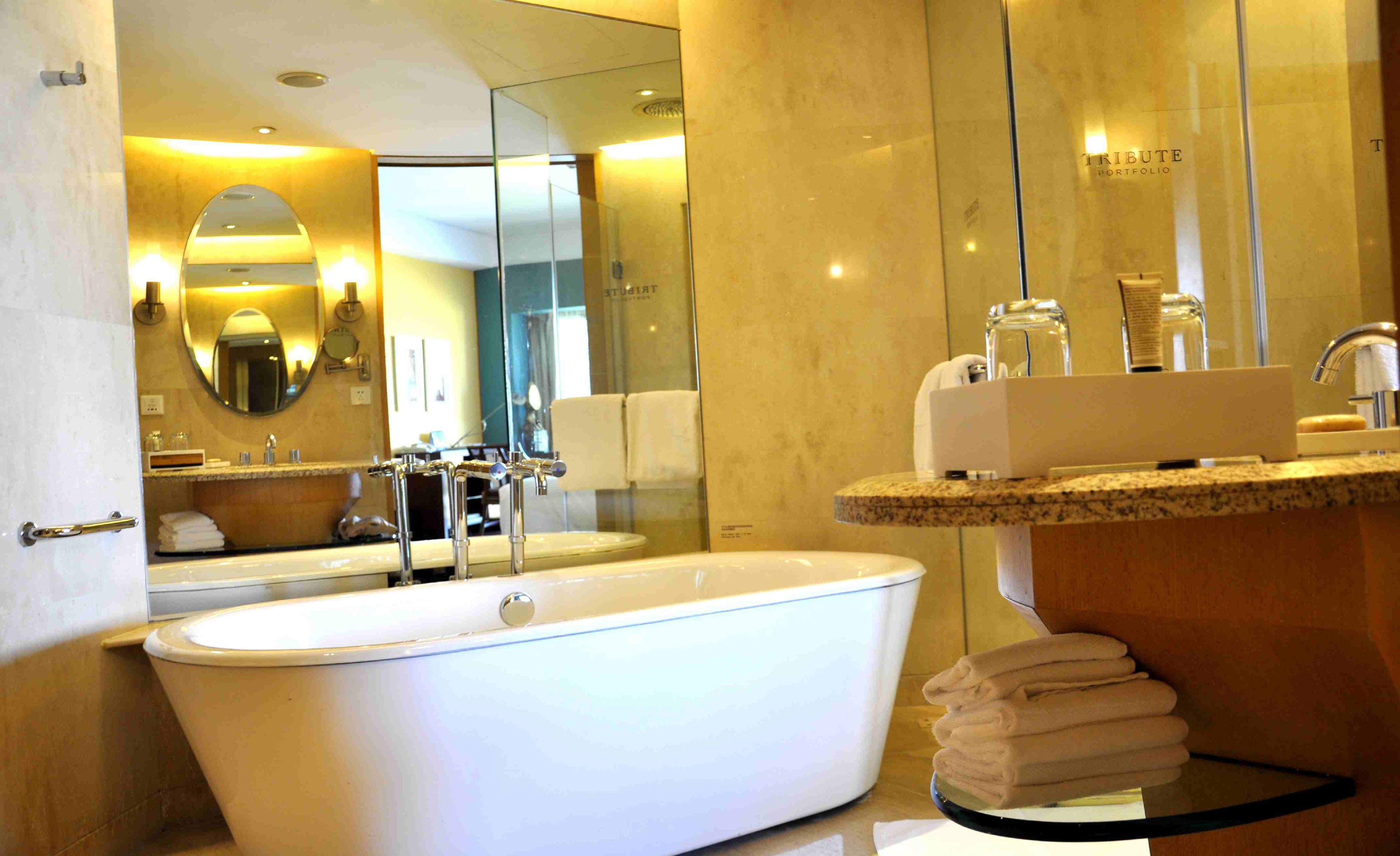 A modern bathroom with a freestanding bathtub, a vanity with a sink, and a large mirror.