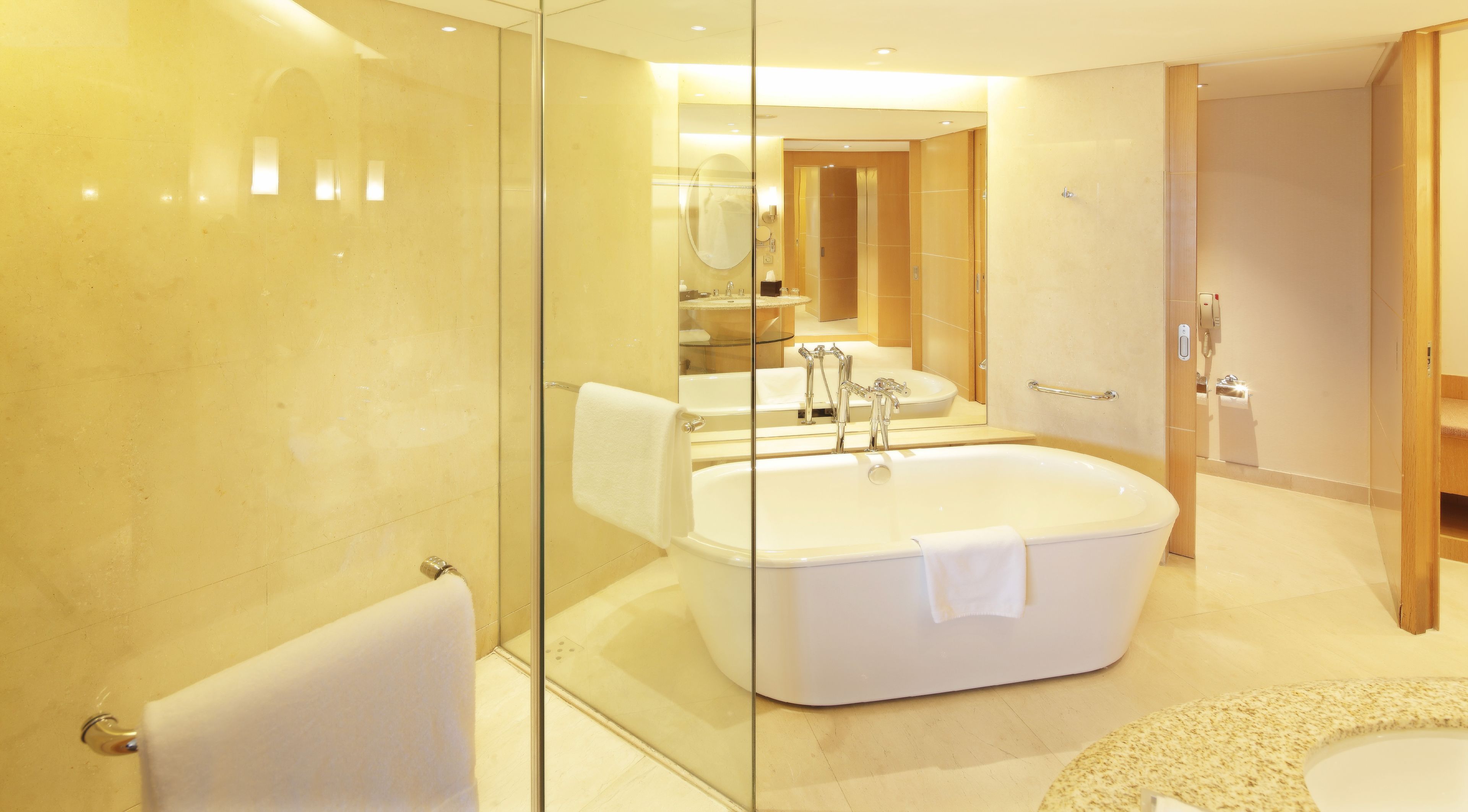 Un baño moderno con una bañera independiente grande, ducha con cerramiento de vidrio y una zona de lavamanos separada.