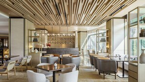 A modern interior with a central seating area, a bar with shelves, and large windows. - Le Méridien Shanghai Sheshan (Shanghai)