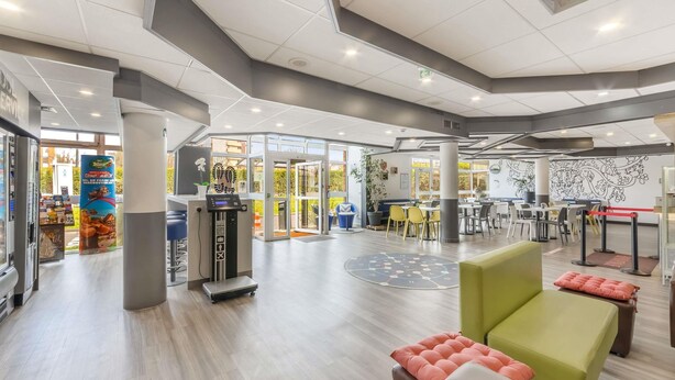 A spacious indoor area with a reception desk, seating arrangements, and a visible Starbucks entrance.