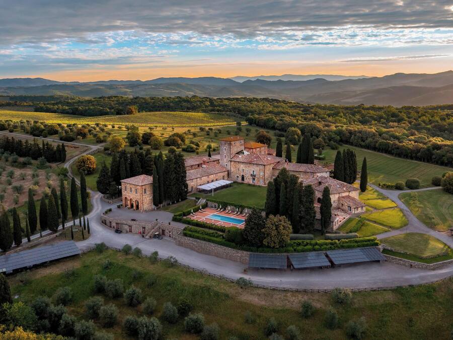 A historic estate with a central courtyard, surrounded by lush gardens and vineyards.