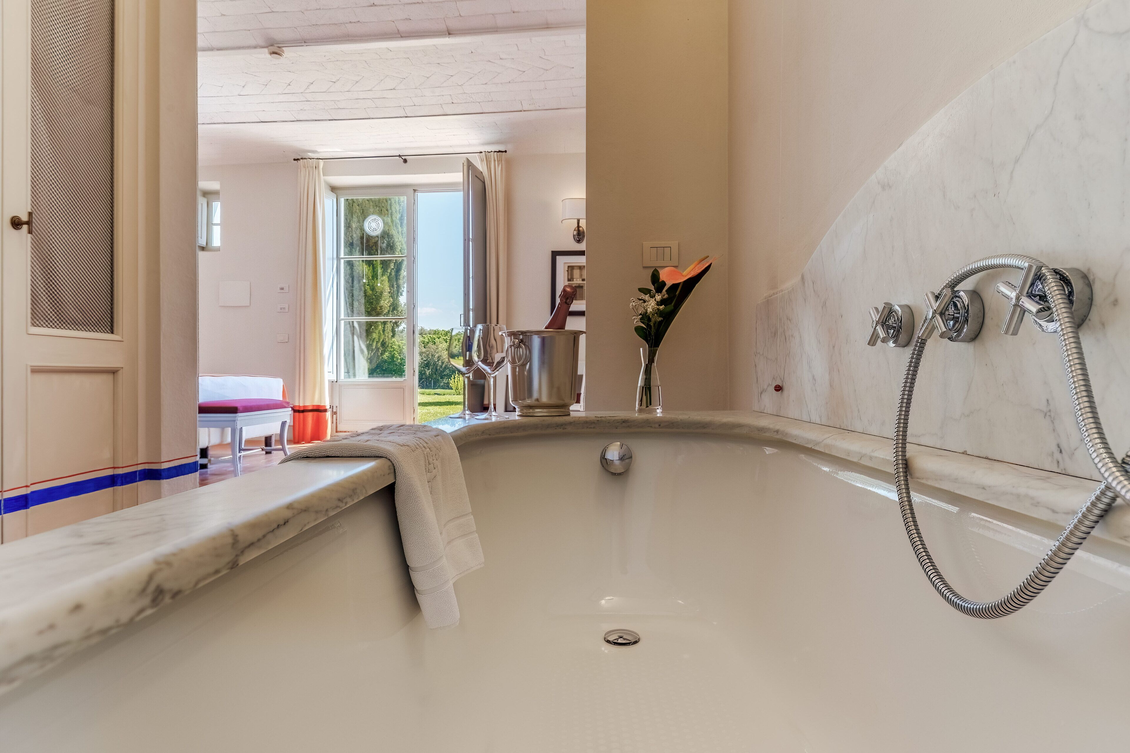 Un baño con una bañera grande, ducha y encimera de mármol.