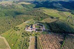 An aerial view of a rural estate with a large house surrounded by fields and trees. - Borgo Scopeto Wine & Country Relais (Castelnuovo Berardenga)