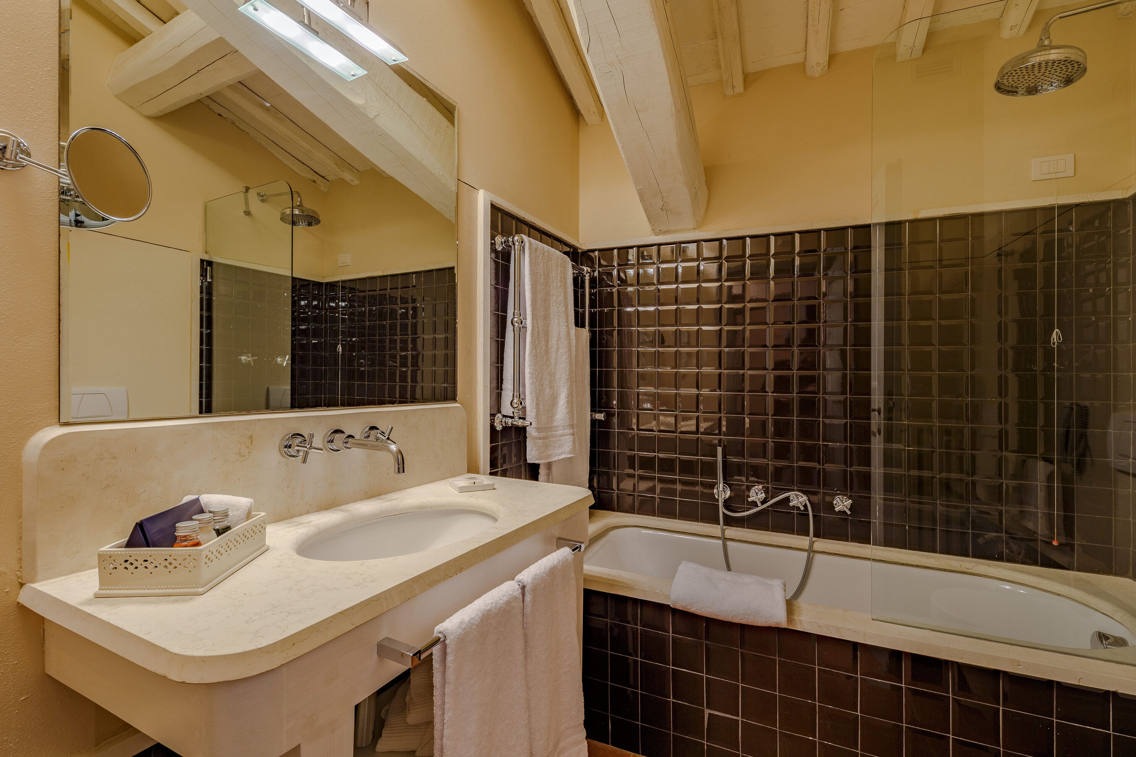 A bathroom with a double sink, a bathtub, a shower, and a large mirror.