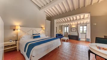 Une chambre spacieuse avec un grand lit, un bureau et une chaise. Il y a une fenêtre avec des rideaux et une vue sur l’extérieur.