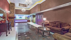 En lobby med reception, sofa, sofabord og en lysekrone.