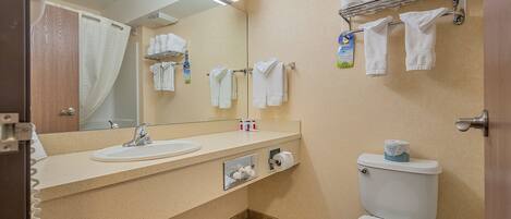 A bathroom with a sink, mirror, towel rack, and toilet.