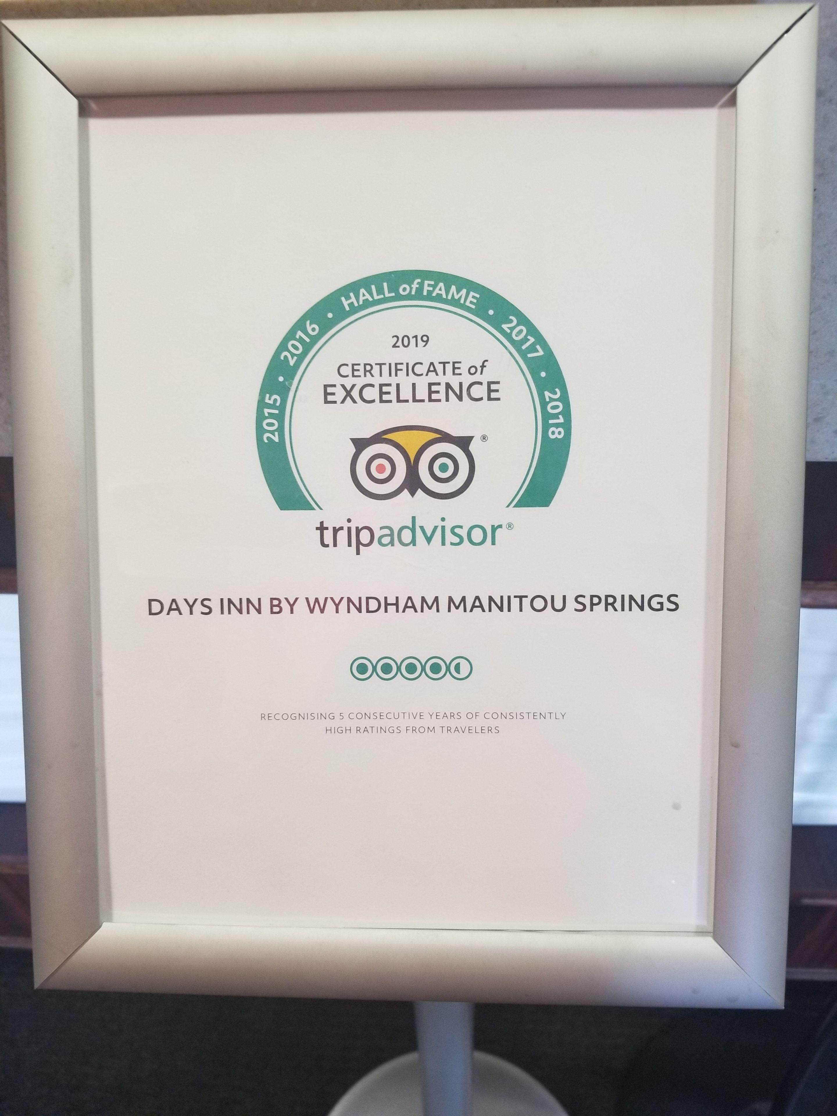 A framed TripAdvisor certificate of excellence for Days Inn by Wyndham Manitou Springs, recognizing 5 consecutive years of high ratings.