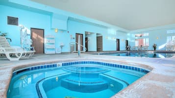 Una piscina interior con una fuente de agua cristalina, un vestuario y una zona de estar con sillas.