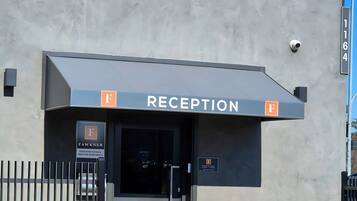 A reception area with a sign indicating it's open, a gated entrance, and a building facade.