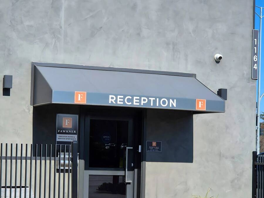 A reception area with a sign indicating it's open, a gated entrance, and a building facade.