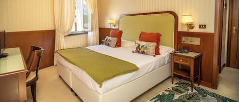 Une chambre d’hôtel avec un lit, un bureau et une chaise.