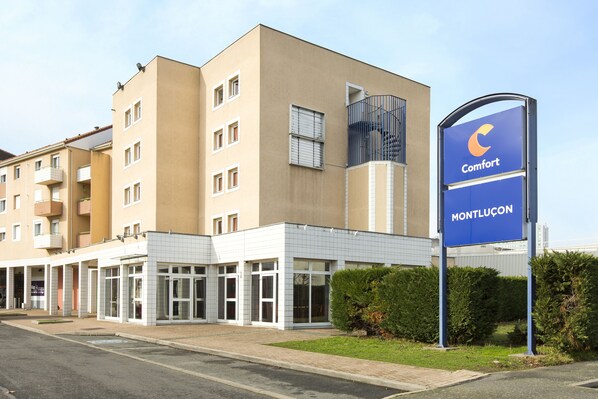 Un moderno edificio de hotel con un letrero que dice "Comfort Montlucon".