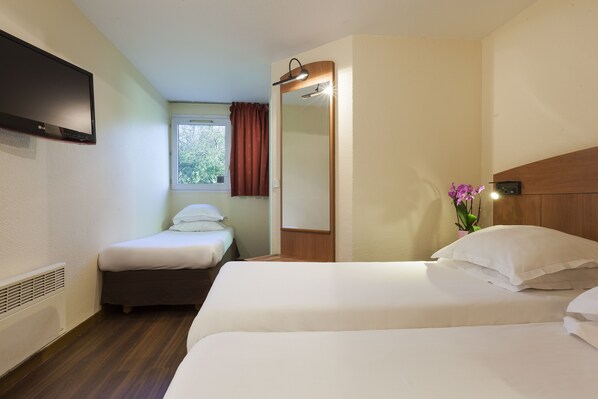 A hotel room with two beds, a TV, a window with curtains, a mirror, and a small plant. - Comfort Hotel Amiens Nord (Amiens)