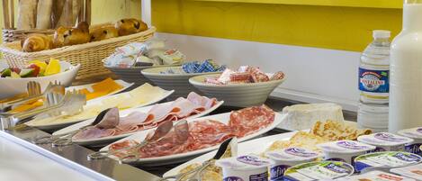A buffet with various food items including meats, cheeses, and dairy products.
