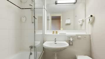 A bathroom with a glass shower enclosure, a white sink, and a toilet.