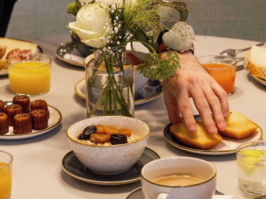 A breakfast setting with various dishes, including a bowl of cereal, toast, and fruit.