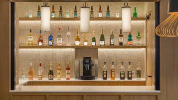 A bar area with multiple shelves of liquor bottles and a coffee machine.