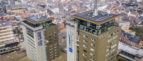 Two high-rise buildings with modern architecture, featuring prominent signage and a flat roof design.