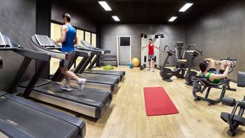 Een sportschool met loopbanden, trainingsballen en krachtapparaten.