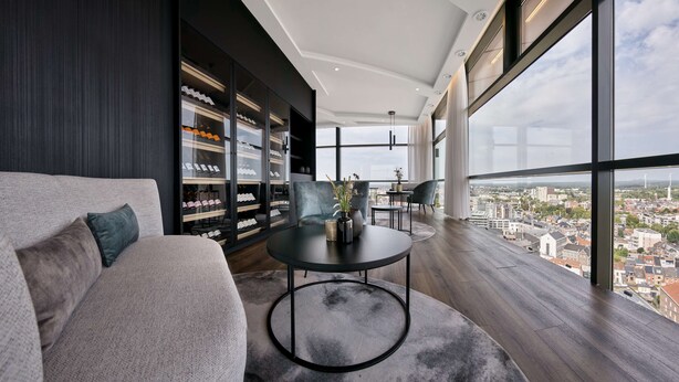 A modern living room with a sofa, a round table, and a bookshelf. - Radisson Blu Hotel, Hasselt (Hasselt)