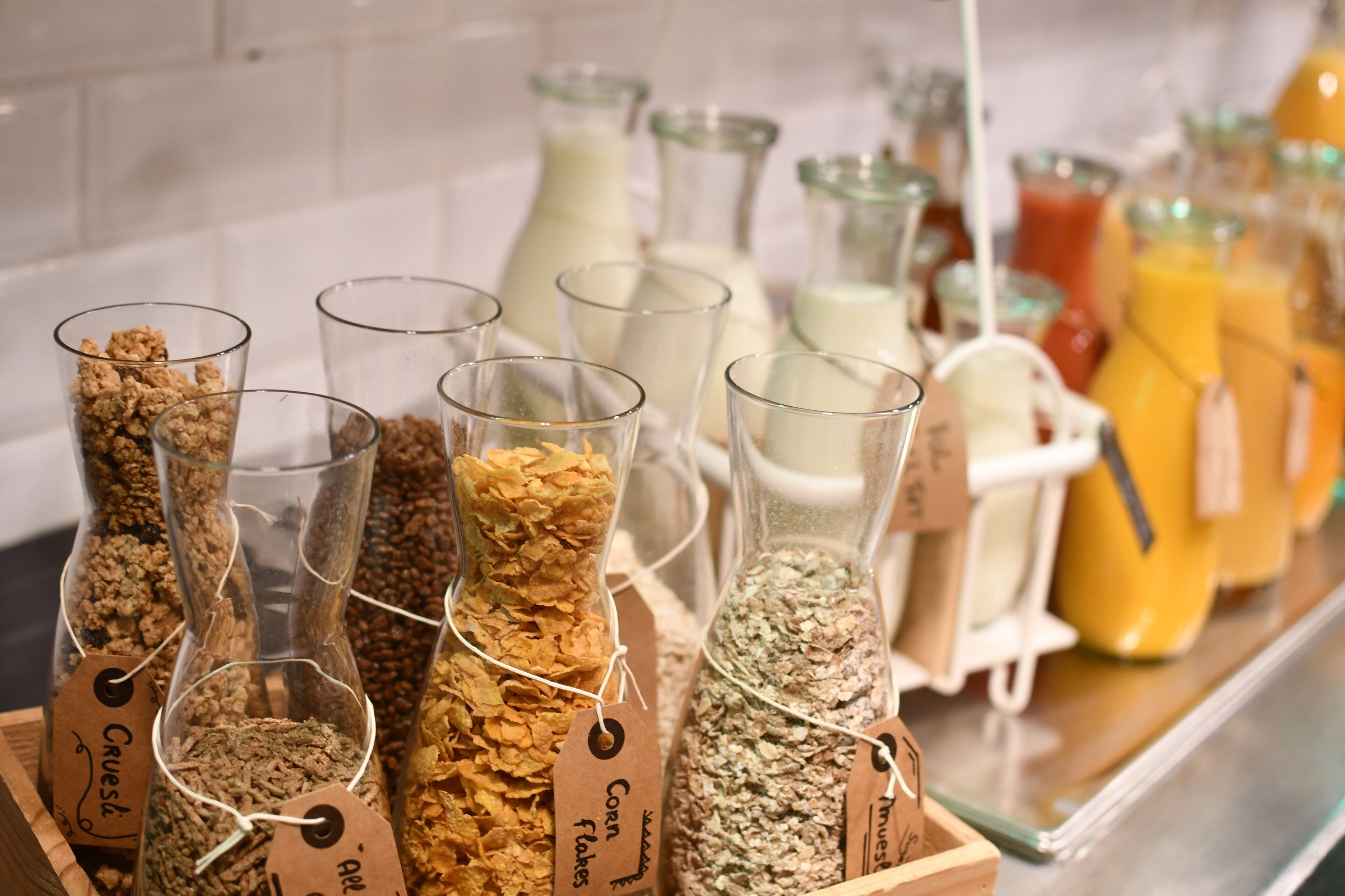 Un buffet de petit-déjeuner proposant différents types de céréales et des portions individuelles de lait.