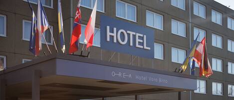 A hotel sign with multiple flags and the name "Hotel Vore Brno".
