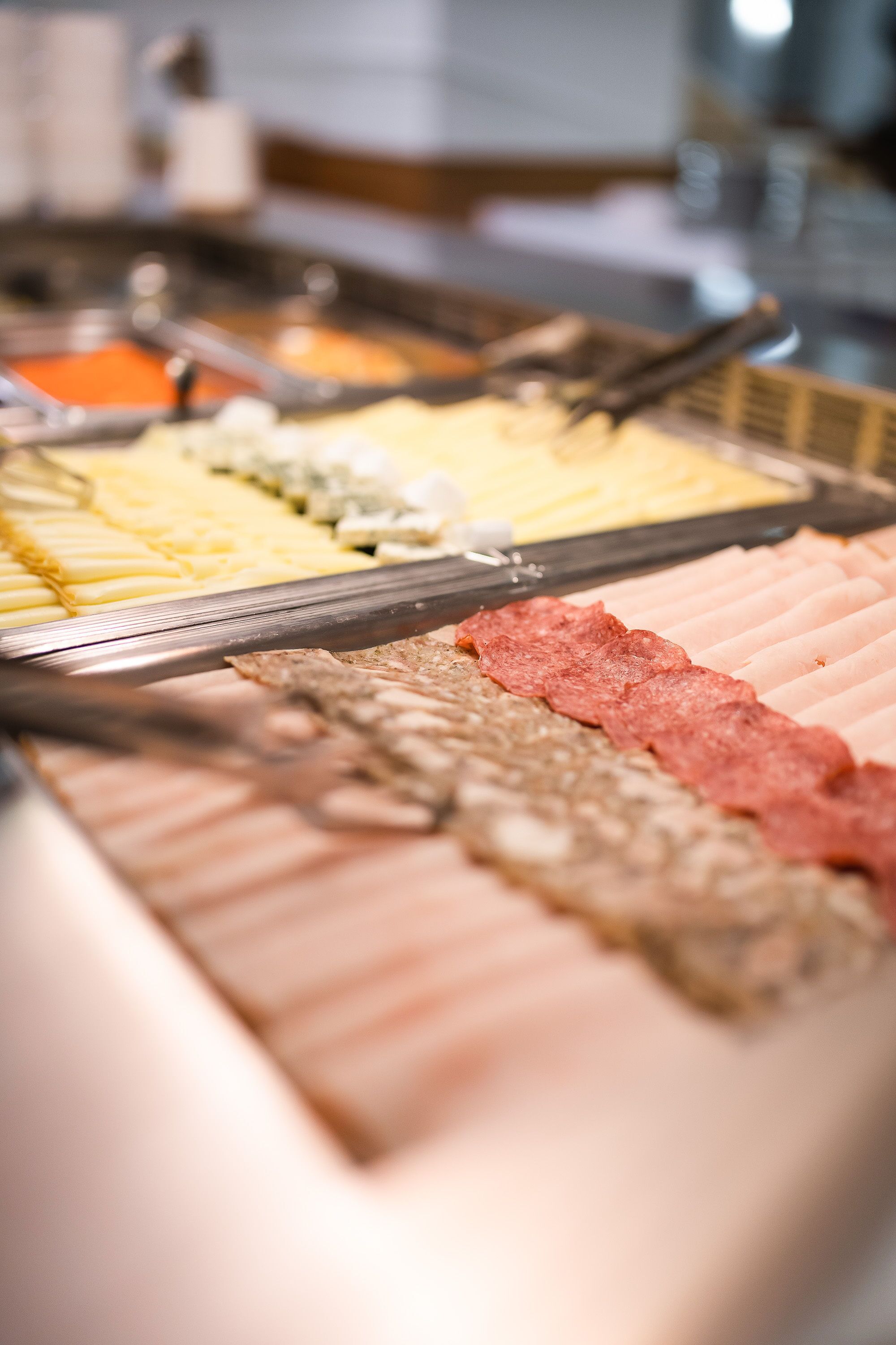 Een buffet met diverse gerechten, waaronder vleeswaren en kazen.