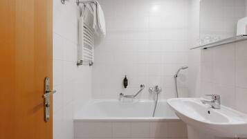 Ein Badezimmer mit einer Badewanne, einem Waschbecken und einem Handtuchhalter.