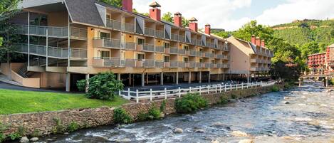 A multi-story hotel with balconies overlooking a river.