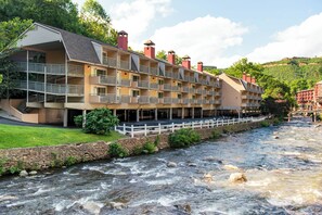 A multi-story hotel with balconies overlooking a river.