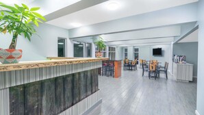 Un vestíbulo amplio con una recepción, zona de estar y una planta grande en maceta.