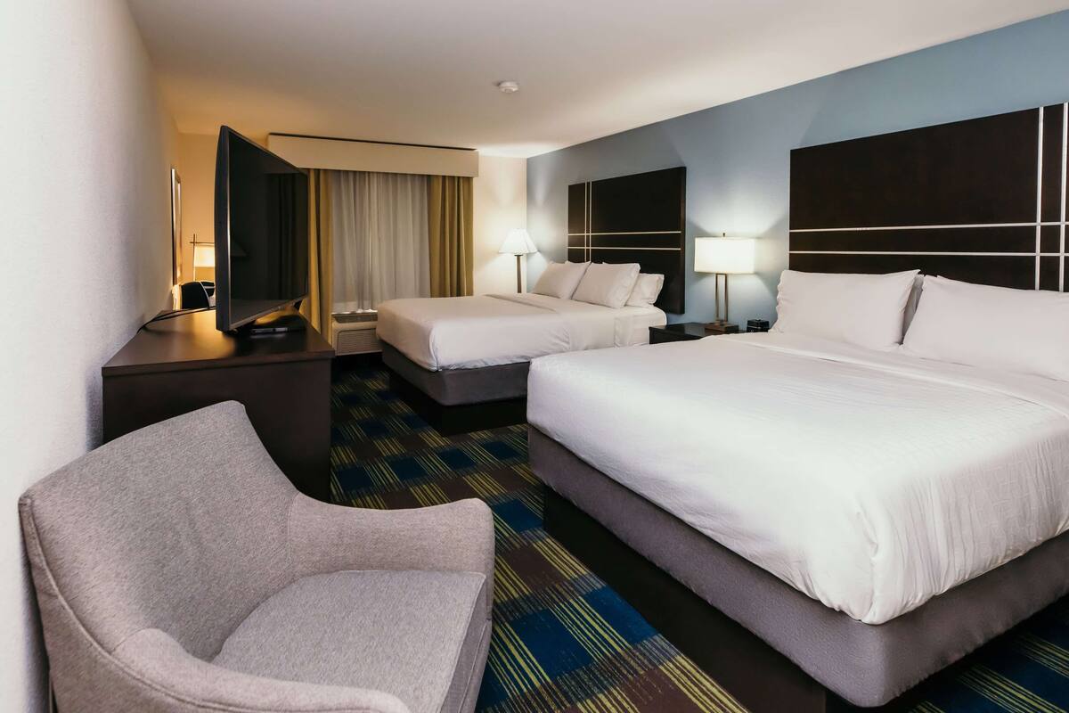 Een hotelkamer met twee bedden, een bank, een bureau en een televisie.