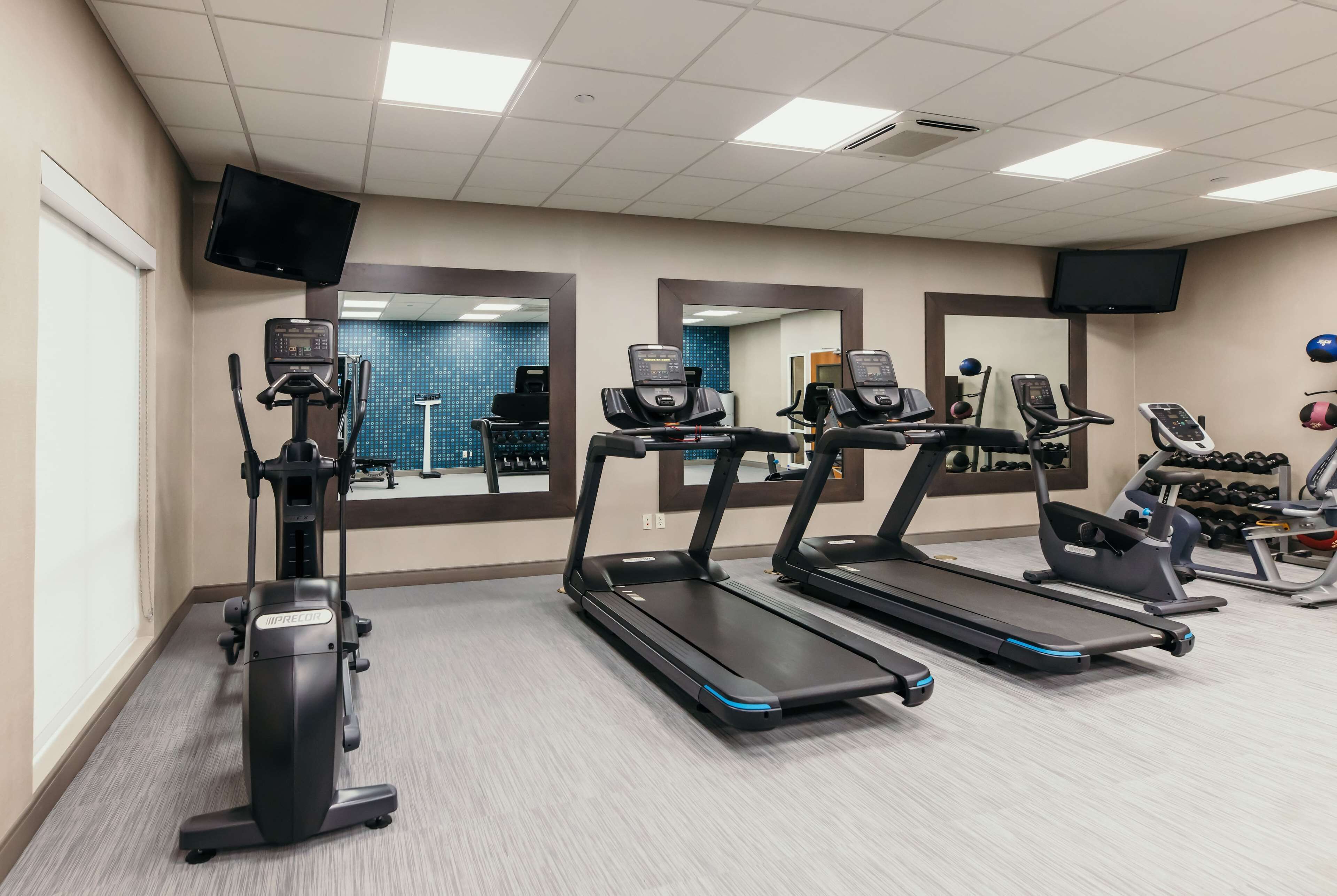 Ein Fitnessraum mit Laufbändern, Crosstrainern und Ergometer.