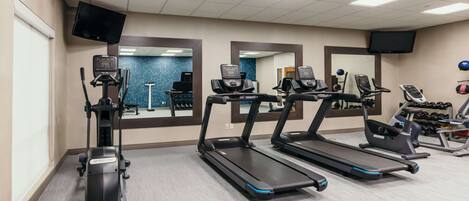 Ein Fitnessraum mit Laufbändern, Crosstrainern und Ergometer.