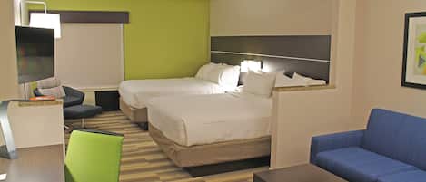 Ett hotellrum med två sängar, ett skrivbord, en stol och en soffa.