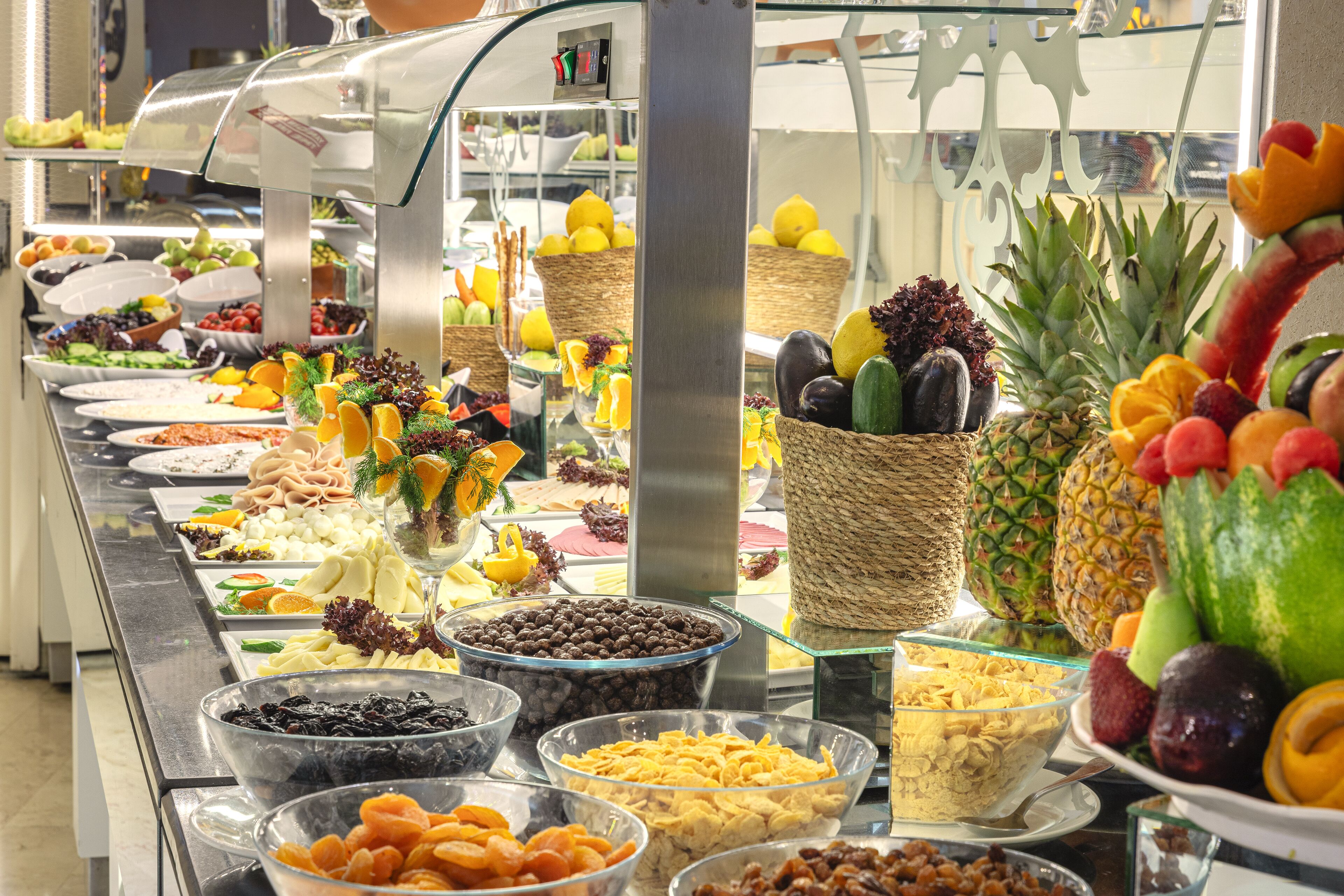 A buffet with various food items including fruits, vegetables, and cereals.