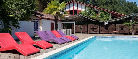 Piscine extérieure en saison, chaises longues