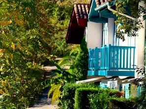 Un sendero que conduce a un edificio con valla azul y techo rojo.
