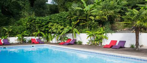 Una piscina al aire libre de temporada, sillones reclinables de piscina
